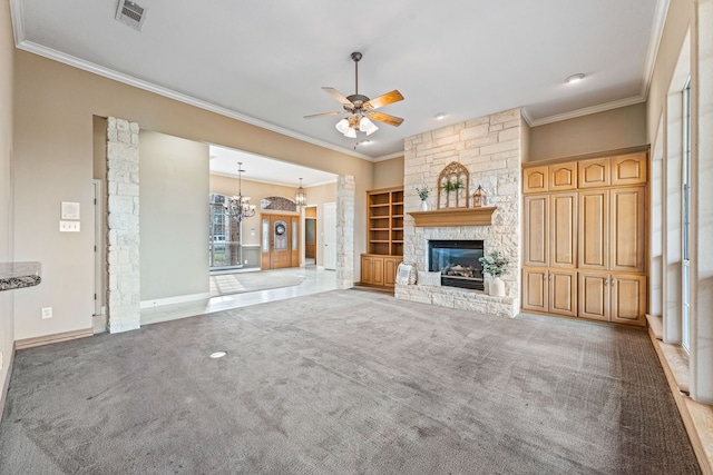 unfurnished living room featuring ornamental molding, ceiling fan with notable chandelier, light colored carpet, and a fireplace