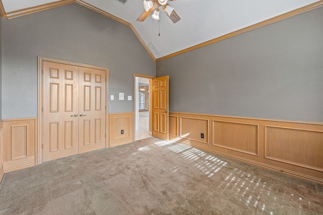 unfurnished bedroom featuring crown molding, ceiling fan, high vaulted ceiling, light carpet, and a closet