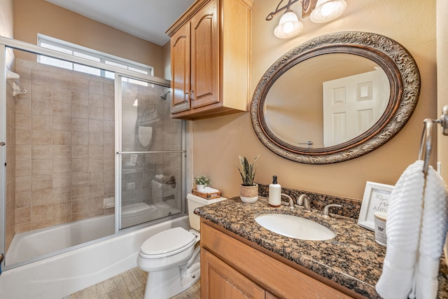 full bathroom with vanity, enclosed tub / shower combo, and toilet