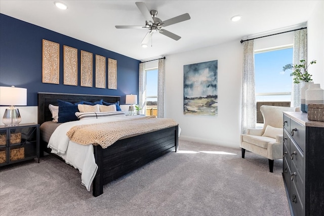 carpeted bedroom with ceiling fan and a water view