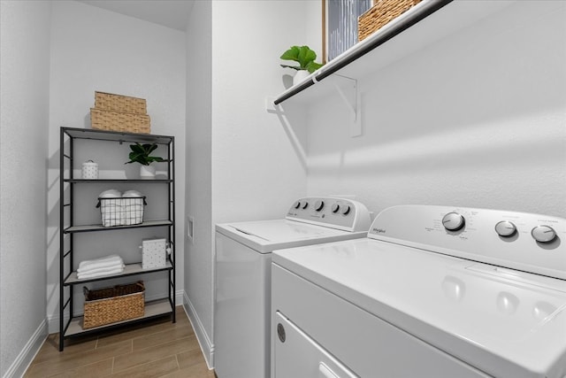 laundry room with light wood-type flooring and washing machine and clothes dryer