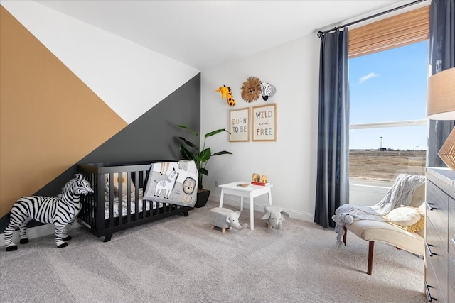 carpeted bedroom featuring a nursery area and lofted ceiling