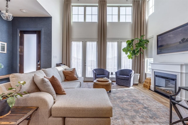 living room featuring hardwood / wood-style flooring, a high ceiling, and a wealth of natural light