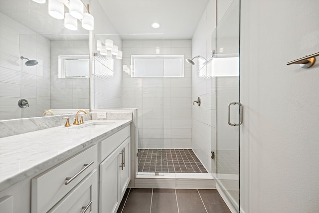 bathroom with vanity and a shower with door