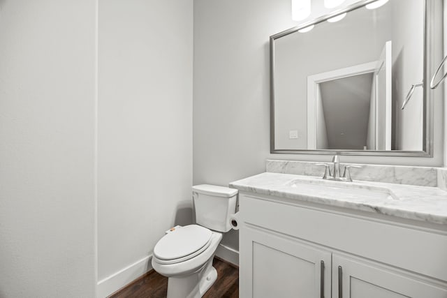 bathroom with hardwood / wood-style flooring, vanity, and toilet