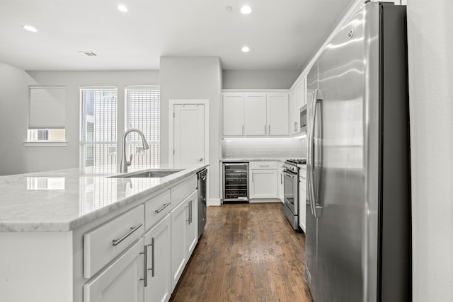 kitchen with dark wood-type flooring, sink, wine cooler, appliances with stainless steel finishes, and white cabinetry