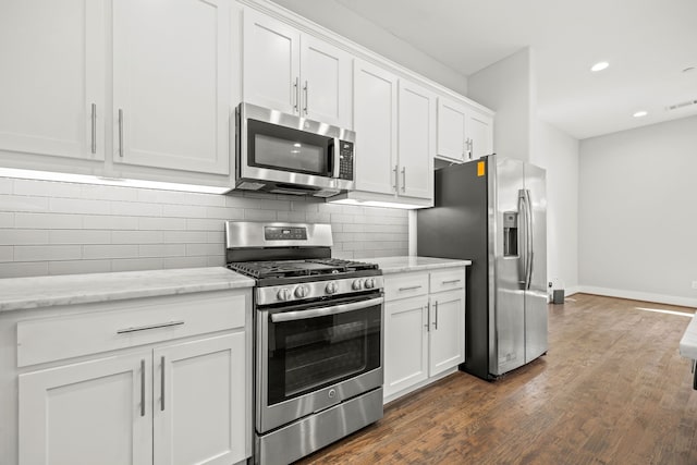 kitchen featuring light stone countertops, white cabinetry, dark wood-type flooring, and stainless steel appliances