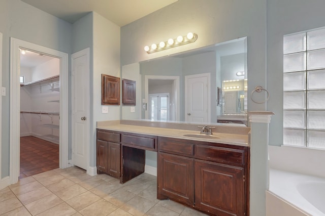 bathroom featuring tile patterned flooring, vanity, and a bathing tub