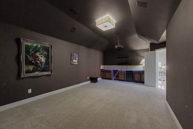 cinema featuring baseboards, visible vents, vaulted ceiling, and carpet flooring