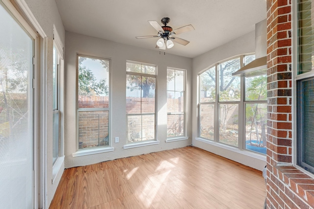 unfurnished sunroom with a ceiling fan