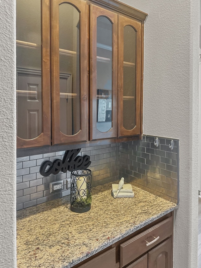 kitchen featuring light stone counters and backsplash