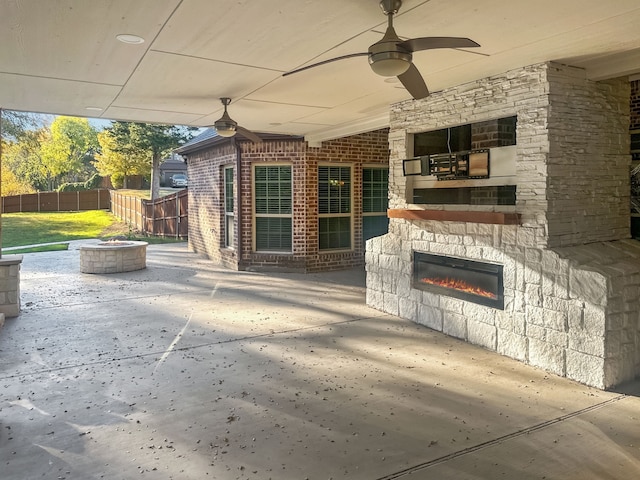 view of patio / terrace featuring ceiling fan, a fire pit, and an outdoor stone fireplace