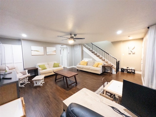 living room featuring ceiling fan, dark wood-type flooring, and a textured ceiling