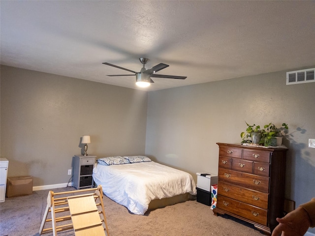 bedroom with ceiling fan, carpet floors, and a textured ceiling