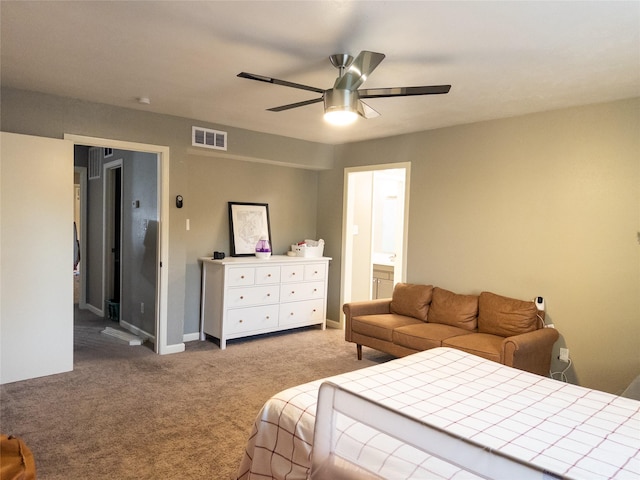 carpeted bedroom with ensuite bath and ceiling fan