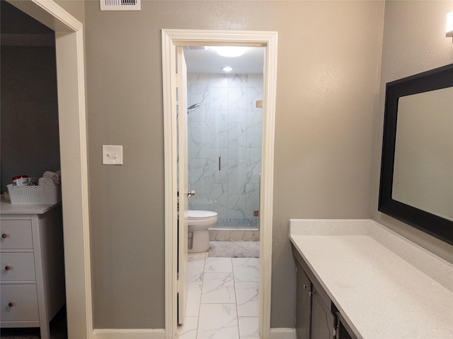 bathroom featuring vanity, toilet, and a shower with shower door