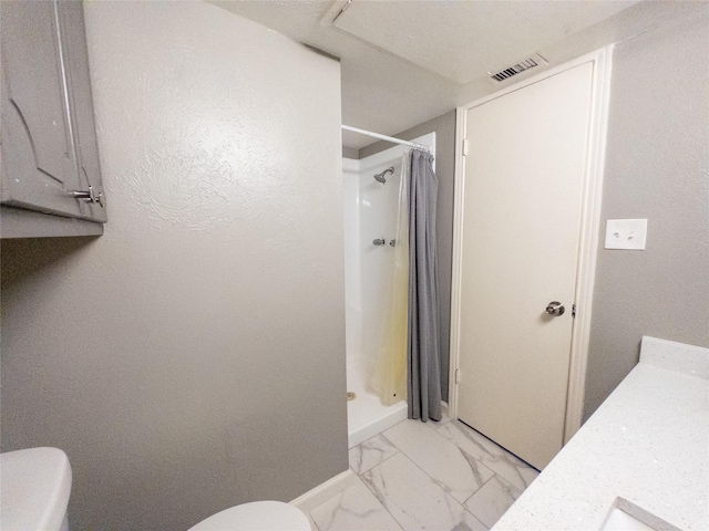 bathroom featuring walk in shower, vanity, and toilet