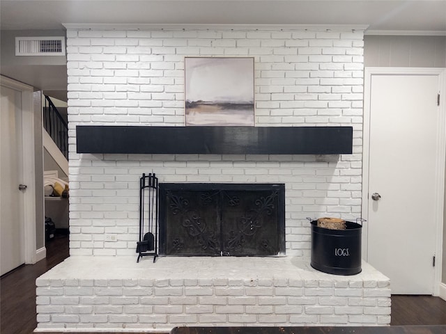 details featuring hardwood / wood-style flooring, crown molding, and a fireplace