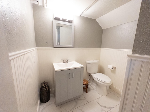 bathroom with vanity, lofted ceiling, and toilet