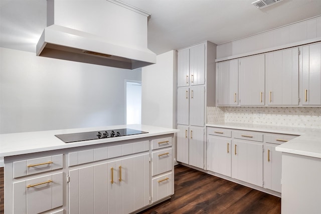 kitchen with black electric stovetop, tasteful backsplash, dark wood-type flooring, white cabinets, and range hood