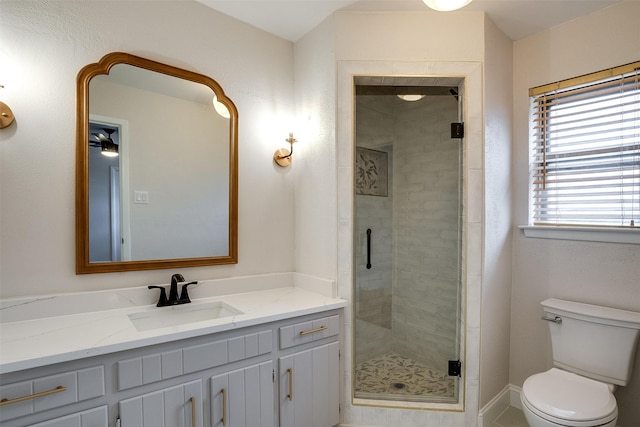 bathroom featuring toilet, ceiling fan, an enclosed shower, and vanity