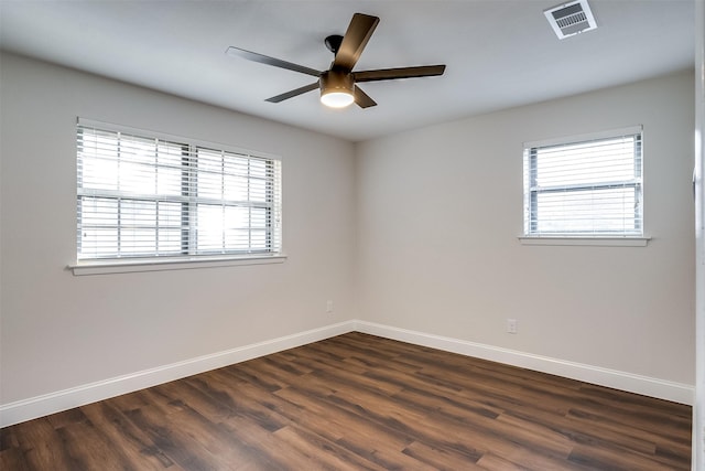 unfurnished room featuring ceiling fan, dark hardwood / wood-style flooring, and a healthy amount of sunlight