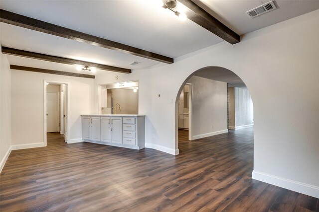 unfurnished living room with beamed ceiling and dark hardwood / wood-style floors