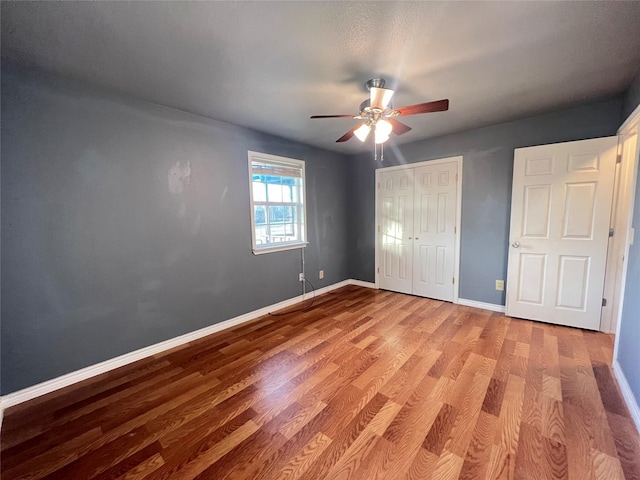 unfurnished bedroom featuring light hardwood / wood-style flooring, a closet, and ceiling fan