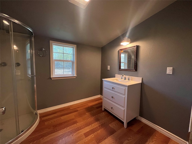 bathroom with vanity, vaulted ceiling, hardwood / wood-style floors, and an enclosed shower