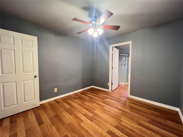 unfurnished bedroom with ceiling fan, ensuite bathroom, and light hardwood / wood-style floors