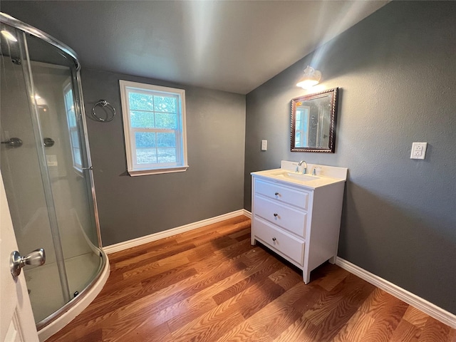 bathroom with hardwood / wood-style flooring, vanity, and a shower with door