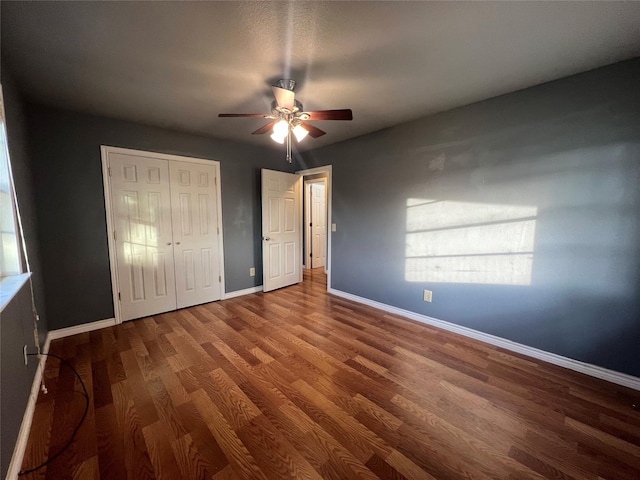 unfurnished bedroom with hardwood / wood-style flooring, ceiling fan, and a closet