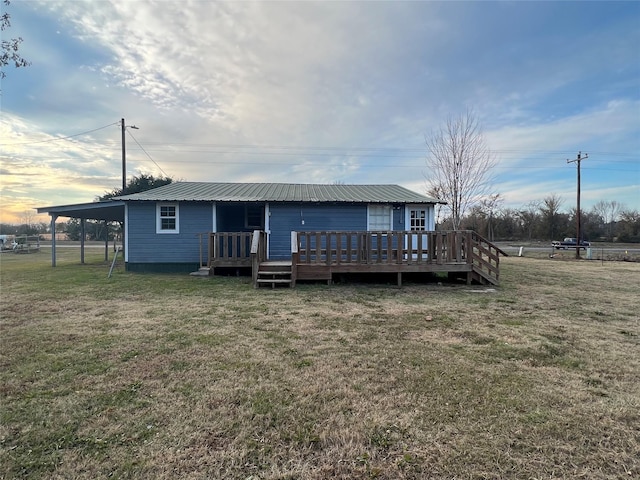 rear view of property with a lawn and a deck