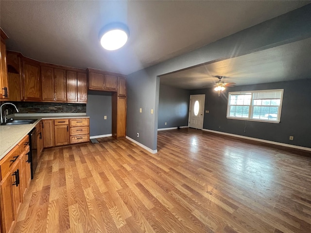 kitchen with sink, backsplash, light hardwood / wood-style floors, and ceiling fan