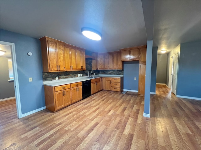 kitchen featuring sink, decorative backsplash, light hardwood / wood-style floors, and dishwasher