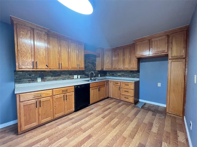 kitchen with dishwasher, sink, backsplash, and light hardwood / wood-style floors