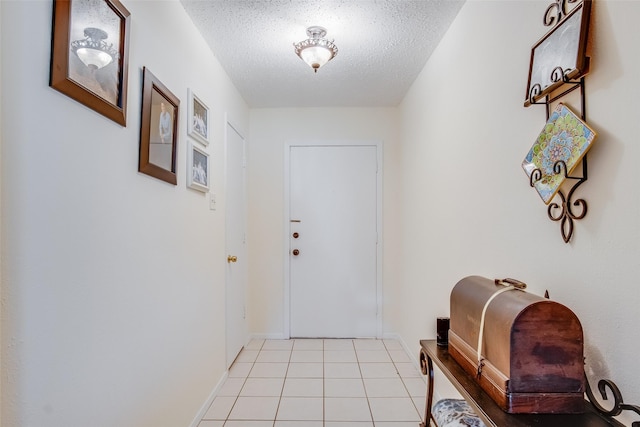 entryway with a textured ceiling and light tile patterned flooring