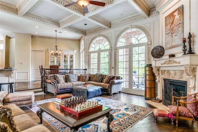 living room featuring french doors, coffered ceiling, crown molding, beamed ceiling, and a premium fireplace