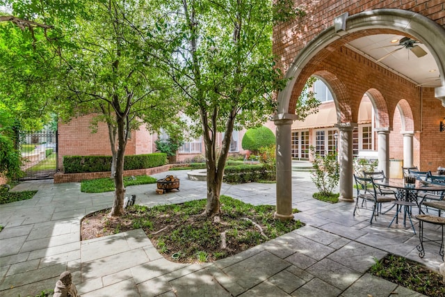 view of patio with ceiling fan and an outdoor fire pit