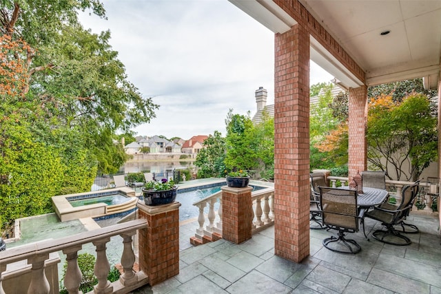 view of patio / terrace with a swimming pool with hot tub