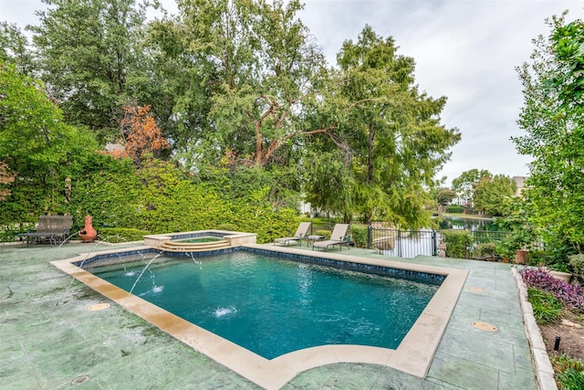 view of pool featuring an in ground hot tub, pool water feature, and a patio