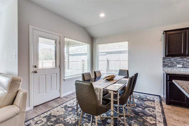 dining room with lofted ceiling and light hardwood / wood-style flooring