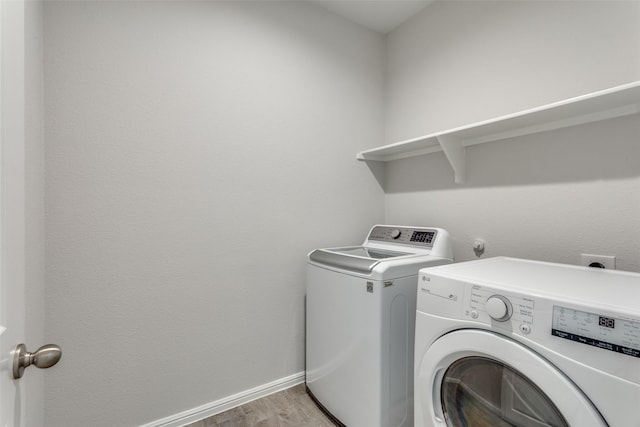 clothes washing area featuring light hardwood / wood-style floors and washing machine and clothes dryer