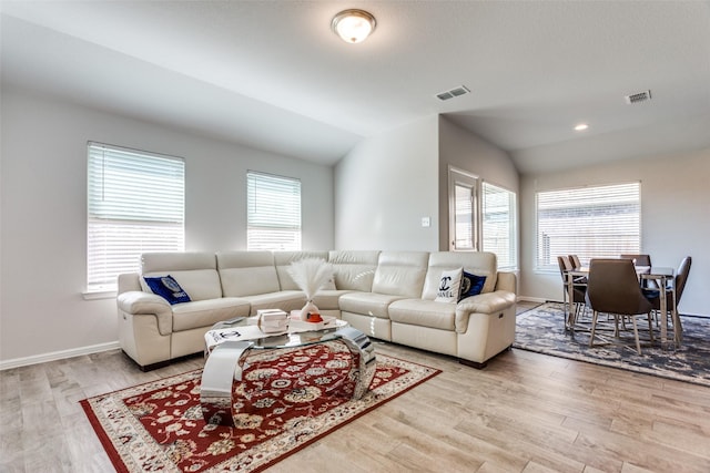 living room featuring light hardwood / wood-style floors and lofted ceiling