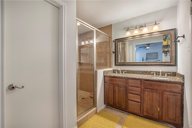 bathroom featuring tile patterned floors, a shower with shower door, and vanity