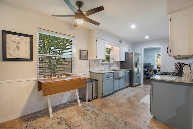 kitchen featuring white cabinetry, sink, light tile patterned floors, and stainless steel appliances