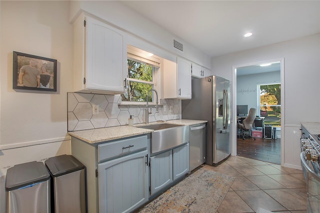 kitchen with sink, gray cabinets, plenty of natural light, stainless steel appliances, and white cabinets