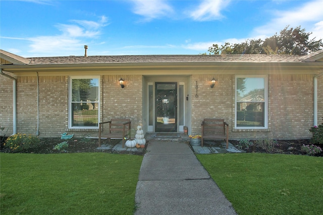 view of exterior entry featuring a yard