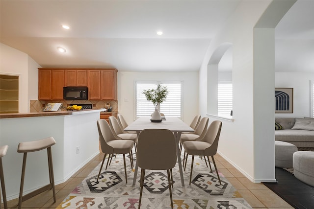 15646 Gatehouse Dr, Fort Worth, TX 76262 - dining area featuring arched walkways, light tile patterned flooring, lofted ceiling, and recessed lighting