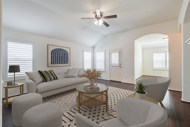 living room with dark wood-style floors, lofted ceiling, arched walkways, and a ceiling fan